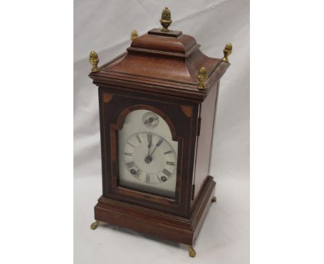 A good quality German bracket clock with silvered arched dial in inlaid mahogany tapered case with brass mounts, 13" high