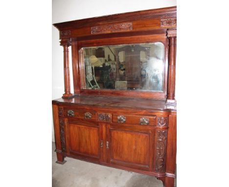 A Victorian carved mahogany mirror back sideboard with two drawers in the frieze and cupboard enclosed by two panel doors, th