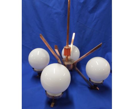 An Art Deco-style copper four branch ceiling light with coral bakelite centre and four opaque glass spherical shades