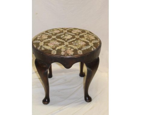 A 1920's walnut oval dressing stool with floral tapestry upholstered seat on cabriole legs