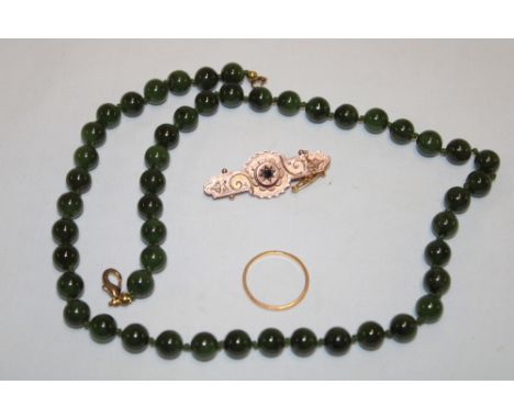 A 9ct gold bar brooch with raised decoration, jade mounted necklace and a plain wedding band