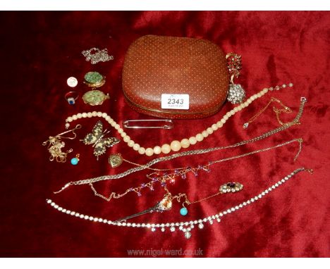 A terracotta coloured jewellery case containing a quantity of costume jewellery including necklace, neck chains, brooches, a 