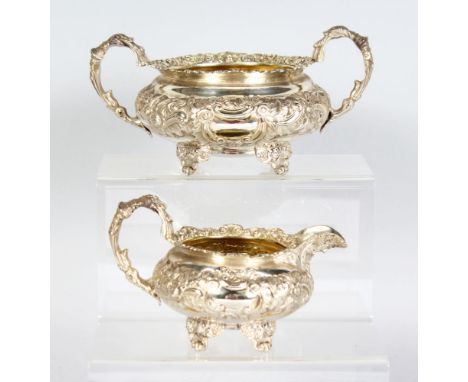 A GEORGE IV SUGAR BASIN AND MILK JUG with floral repousse decoration. London 1822.  Maker: John Bridge.  Weight 20ozs.