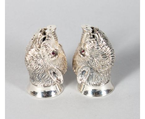 A GOOD PAIR OF SILVER BOAR'S HEAD SALT AND PEPPERS with ruby eyes.