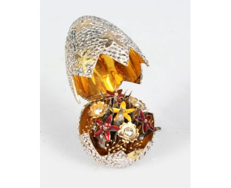 A STUART DEVLIN SILVER EGG, London 1973, the outer egg shell with gilt stars, opening to reveal coloured flowers.