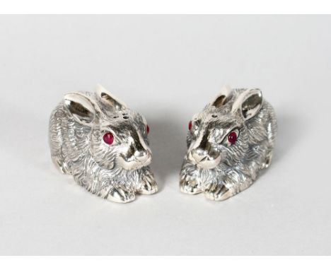 A GOOD PAIR OF SILVER RABBIT SALT AND PEPPERS with ruby eyes.