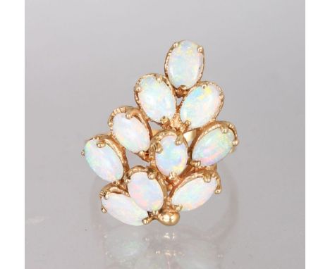 A YELLOW GOLD AND OPAL CLUSTER RING.