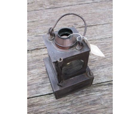 A railway signal lamp interior with reservoir and brass burner, stamped "SAXMUNDHAM"