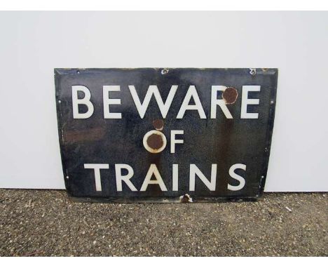 An enamel railway sign "BEWARE OF TRAINS", colour faded