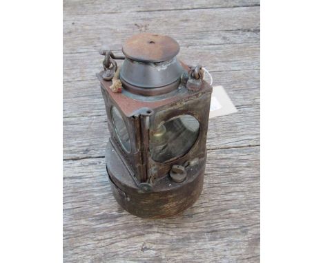 A railway signal lamp interior with circular reservoir and brass burner stamped "DERBY ROAD"