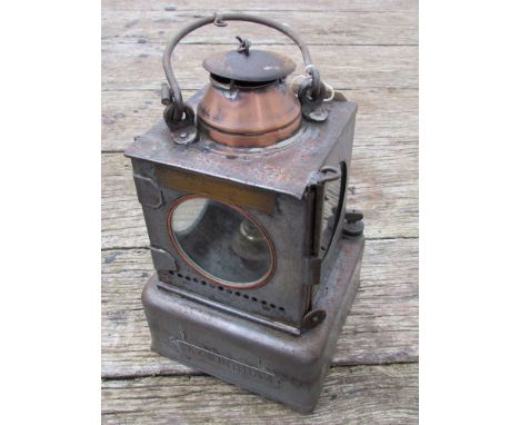 A railway signal lamp interior with reservoir and brass burner, stamped "SAXMUNDHAM"