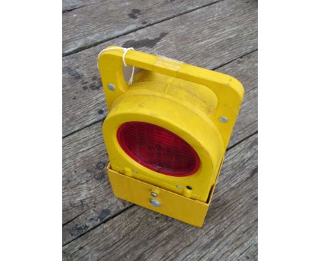 A modern yellow plastic cased battery operated permanent way railman's lamp with two red aspects