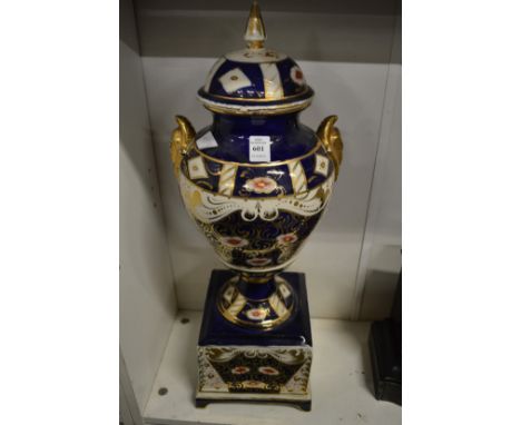 A large porcelain urn on stand decorated in Imari colours (faults).