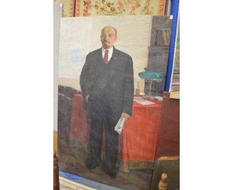 Russian School, Full length portrait of Lenin holding a newspaper standing by a table, oil on canvas, unframed.