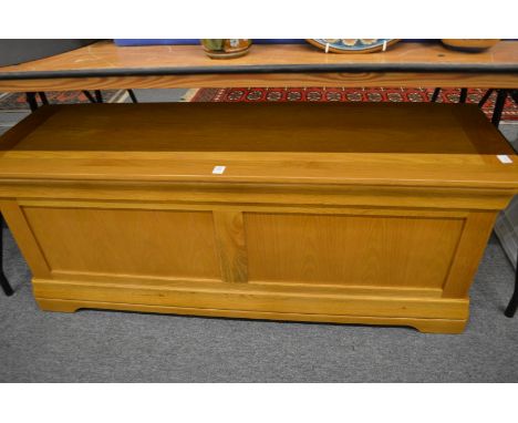 A modern light oak storage box/ottoman.