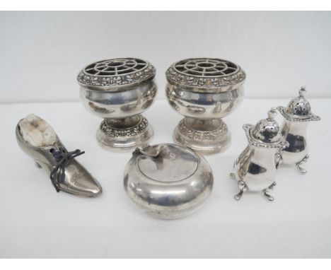 A collection of silver plated items, comprising a pin cushion shoe, candle holder, salt and pepper pots and a pair of miniatu