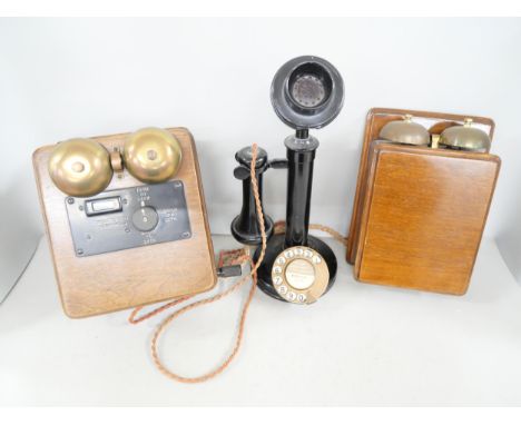 A vintage black enamelled metal candlestick telephone and two oak bell sets 
