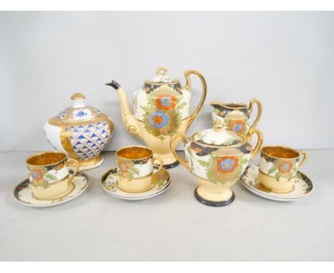 A Japanese handled painted part coffee service, comprising; teapot, sugar bowl, milk jug, five saucers and three cups togethe