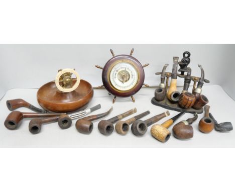 A collection of tobacco pipes, an aneroid barometer and a treen and faux ivory nut cracker in the form of a ships wheel