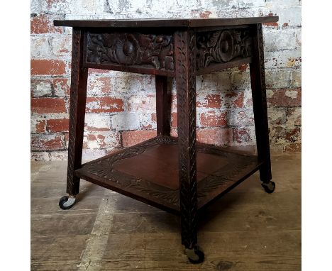 An English oak hall table, profusely carved with floral borders and scale detailed outspleighed legs, large undertier, castor