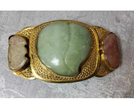 A Chinese gilt metal belt buckle set with a shaped central jade stone, 