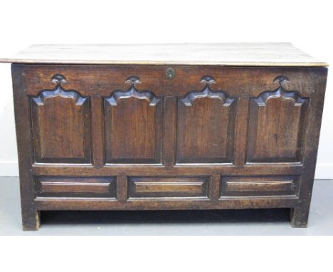 18TH CENTURY WELSH OAK COFFER having loose moulded edge three plank top with bar hinges, above four ogee pointed arch panels 