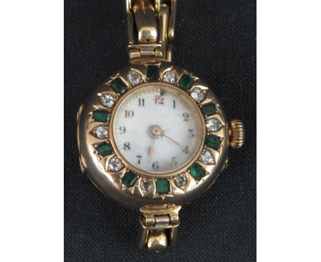 EARLY 20TH CENTURY LADY'S 18CT GOLD BRACELET WRISTWATCH, the face set with diamonds and emeralds around a white enamel dial, 