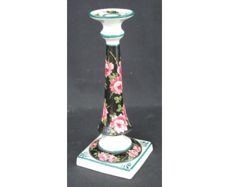 WEMYSS WARE POTTERY CANDLESTICK handpainted with pink roses on a black ground raised on square section base, impressed Wemyss