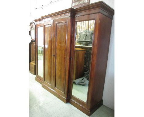 BREAKFRONT WARDROBE, Victorian mahogany with two central panelled doors enclosing sliding trays and four drawers flanked by a