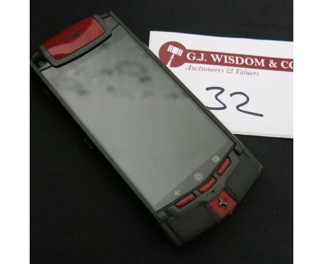 Vertu Ti Ferrari Limited Edition Titanium Phone with Prancing Horse Emblem. Furnished in Red & Black Leather with Carbon Fibr