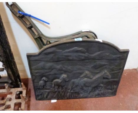 A pair of cast iron bench ends and a cast iron fire back