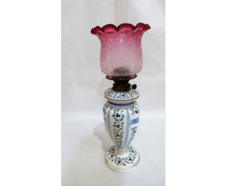 A 19th century milchglass oil lamp painted with trailing foliage, the etched ruby flash shade damaged. 21'' high