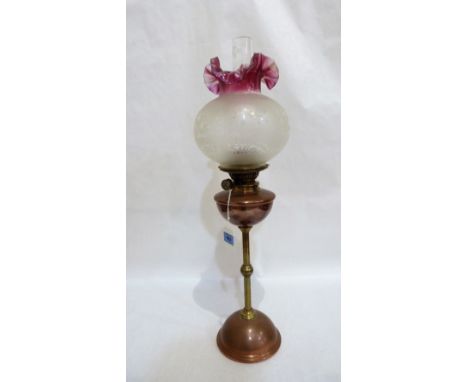 A Victorian copper and vase oil lamp by Hinks, with duplex burner and acid etched ruby flashed crimped shade. 26'' high