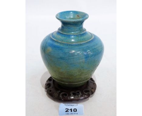 An oriental pottery tapered vase, the cracalure glaze painted in shades of green and turquoise. 4¾'' high. On wood stand