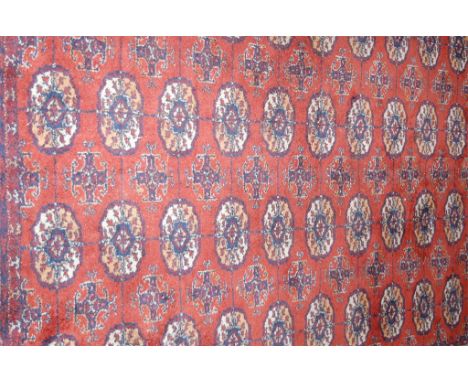 A Persian woollen red ground bokhara rug (with worn patch), 233x175cm