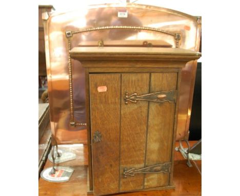 An early 20th century oak and copper bound single door hanging wall cupboard; together with a copper fire screen (2)