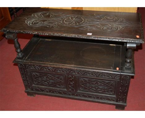 A circa 1900 ebonised oak and low relief floral carved twin panelled monks bench, having typical hinged box seat base, width 