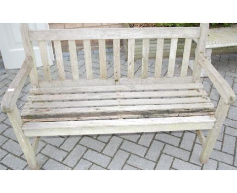 A teak slatted two seater garden bench 
