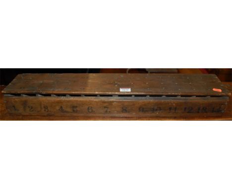 An early 20th century pitched pine ticket dispenser?, with numbered divisions, w.68cm