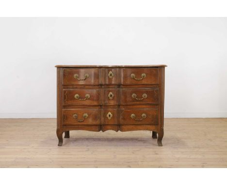 A Louis XV provincial walnut commode, mid-18th century, French, of serpentine outline with all-over strung decoration and bol
