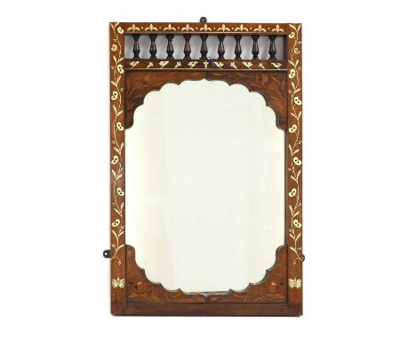 § An Anglo-Indian hardwood and ivory inlaid mirror, c.1900, with a spindle gallery, the frame inlaid with scrolling leaves, b