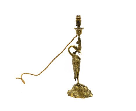 A gilt metal table lamp, in the form of a heron with a fish, with a braided cord and bayonet lightbulb fitting 62cm total hei