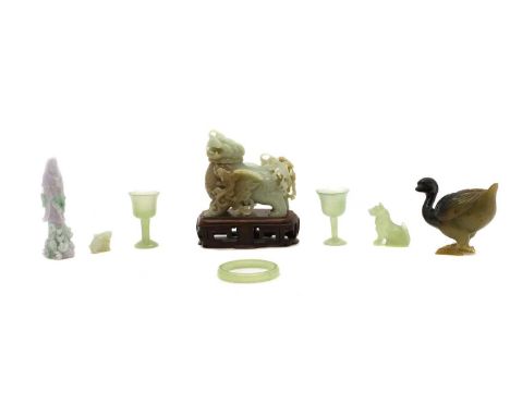 A group of Chinese jade and hardstone carvings, 20th century, comprising a jade Buddhist lion, 12cm long, wood stand, a jade 