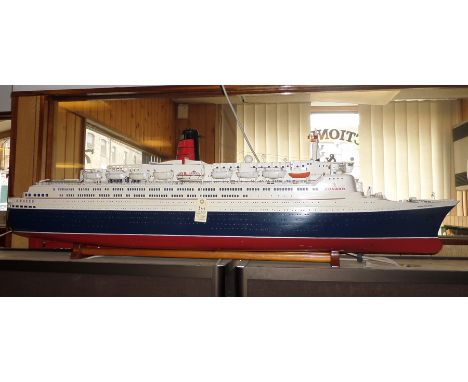 An impressively large-scale model of the Cunard Liner QE2. A well-proportioned wooden model painted in white, black and red l