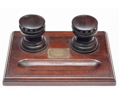 An interesting polished dark oak desk stand from the timbers of HMS Britannia, with 2 inkwells in the form of ships capstans,
