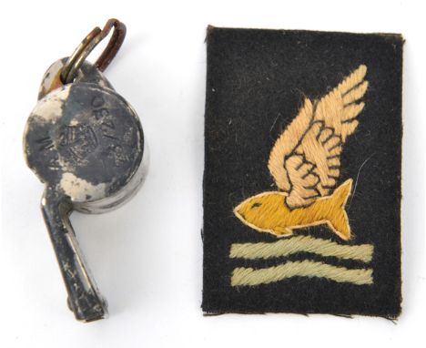 A plated whistle, marked “AM” and crown 23/230 (rust patches) and an embroidered “Goldfish Club” patch. GC                   