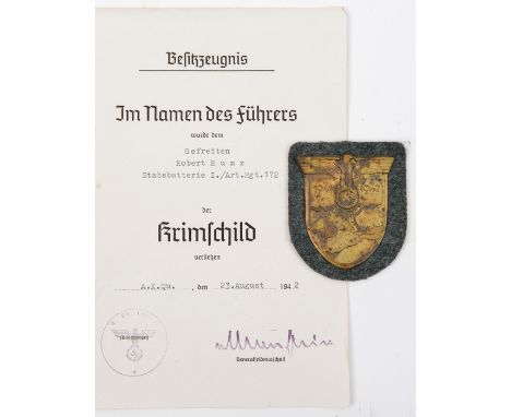 A Third Reich Krim shield, on field grey patch with paper backing (some staining to shield), together with a thin paper award