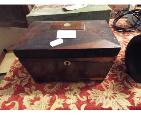 An early 19thC rosewood sarcophagus shaped tea caddy raised on bun feet 