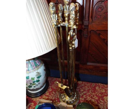 A set of brass fire side tools having figural handles