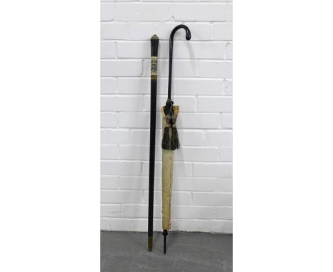 Ebonised sword stick with a brass mounted faux ivory handle and an early 20th century parasol (2) 